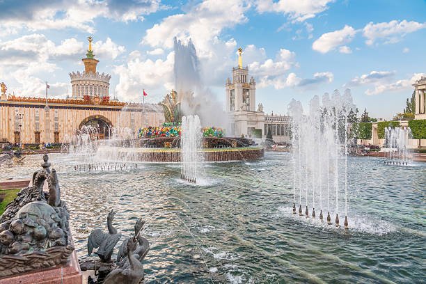 Moscow, Russia - August 4, 2023: Stone Flower fountain and pavilion Ukraine in Exhibition of economic achievements, VDNKh, Moscow, Russia. Splashes of water against light background.